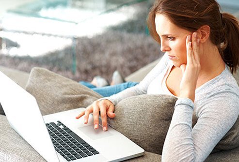 A woman doing research on her lap top computer.