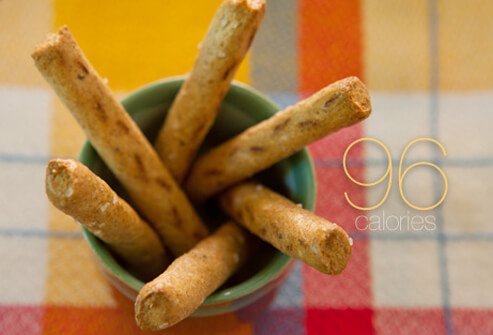Six whole-grain pretzel sticks in a cup.