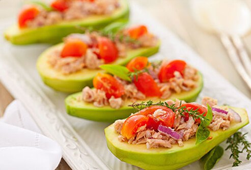 Photo of avocados stuffed with fish and vegetables.
