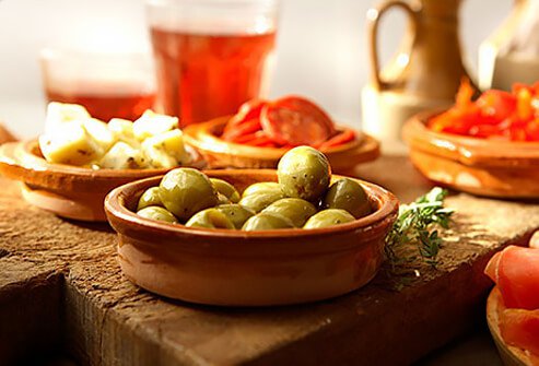 Photo of small plates of olives and cheese.