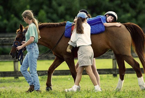 A boy with autism riding a horse and getting horse therapy
