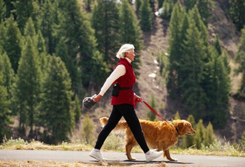 A mature woman taking her dog for a walk