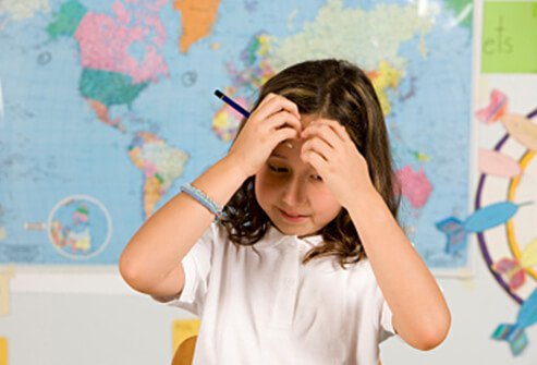 Girl has forgotten how to do an assignment in class.