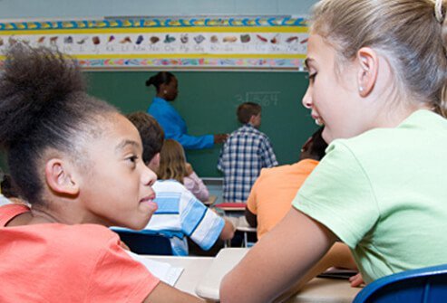 A girl talks excessively to another girl while in class.