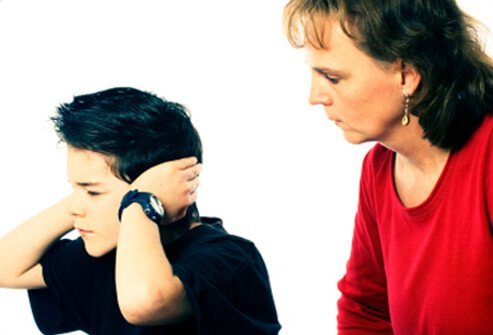 A boy covers his hears and does not listen to his mother.