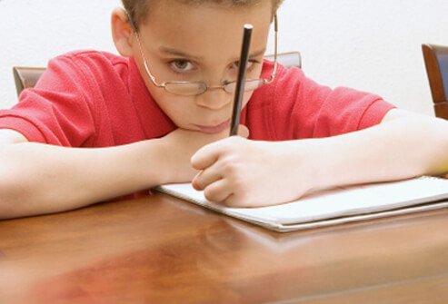 A bored and inattentive boy in school.