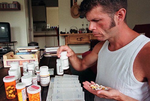 AIDS patient sorts through his daily medications.