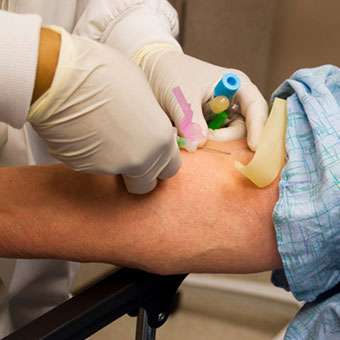 Nurse drawing blood from a patient.
