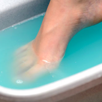 A woman soaks her foot.