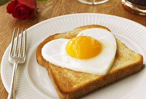 Photo of a heart shaped fried egg on a piece of toast.