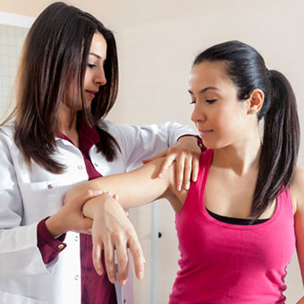 A doctor examines a patient's arm for bedbug bites.