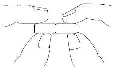 Hold the tablet between your thumbs and index fingers close to the scored line - Illustration