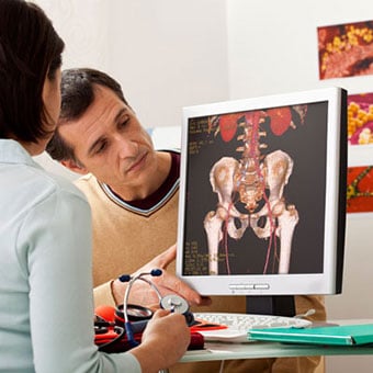 A doctor examines a man experiencing muscle spasms.