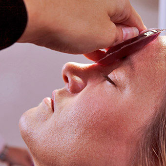 A woman applies a heat compress on a boil.