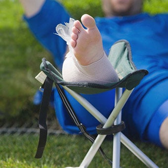 An injured soccer player following the RICE (rest, ice, compression, elevation) method to help decrease pain and swelling for his injury.