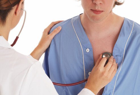 A doctor listening to a patient‘s chest with a stethoscope, diagnosing bronchitis.