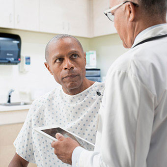 A doctor discusses colonscopy options and procedures with a patient.