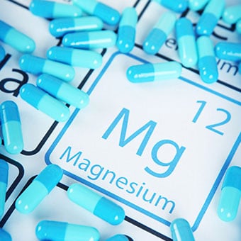 Magnesium supplements on a periodic table with the Mg symbol.