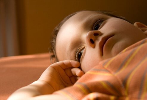 A young boy laying down in a lost state due to dementia.