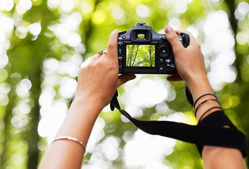 A woman taking photos to embrace her creativity.