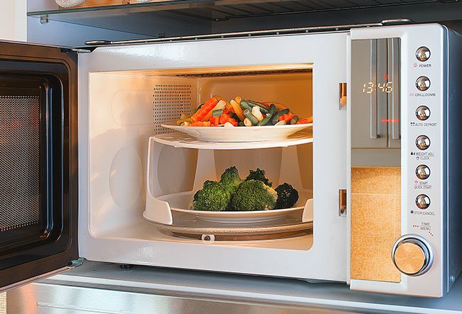 If you follow your microwave's instructions, it is in good working order with no damaged or broken parts, and it automatically shuts off when you open the door, it is safe and won't harm you or your food.