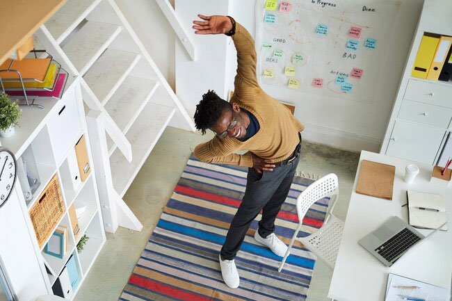 Good home office ergonomics requires taking breaks and stretching.