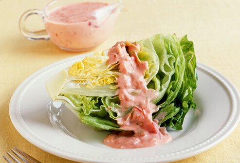A photo wedge of iceberg lettuce with dressing.