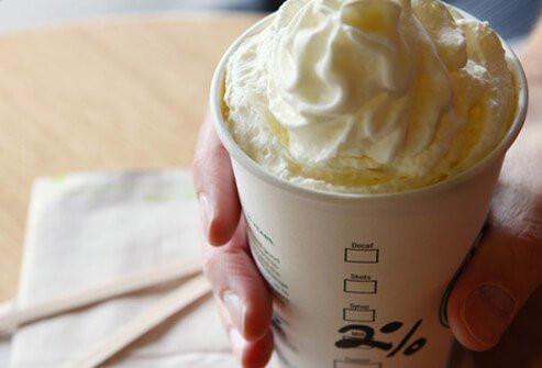 A photo of a 2% milk latte with whipped cream.