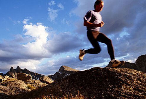 Photo of man running over foothills.