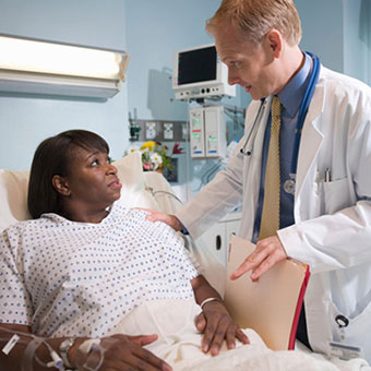 A doctor discusses gallstone prevention and possible after-effects of removal with a patient in the hospital.
