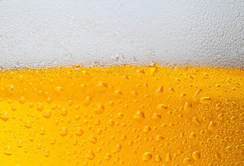 A close up of golden beer with foam head.
