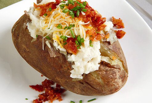 Baked potato with sour cream, cheese, chives, and bacon.