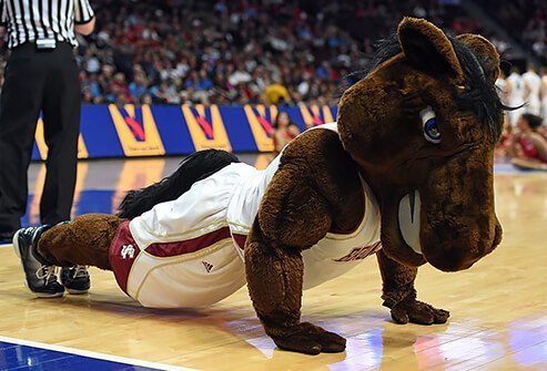 A mustang horse mascot doing push-ups on the basketball court.