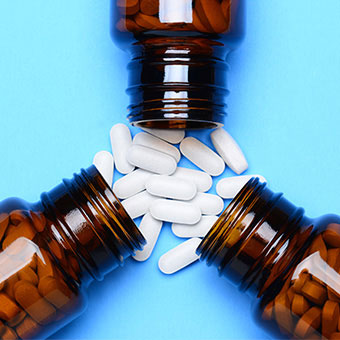 A close-up of three glass prescription bottles.
