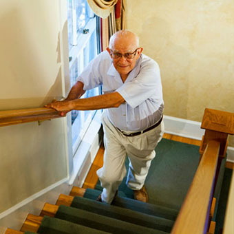 A man experiences hip pain while walking up the stairs.
