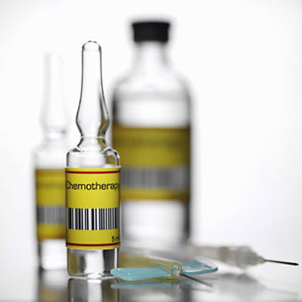 A vial of chemotherapy drugs with needles.