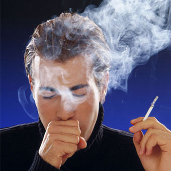 A man coughs while smoking.