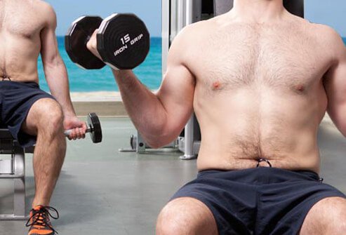 Photo of man using dumbbells.
