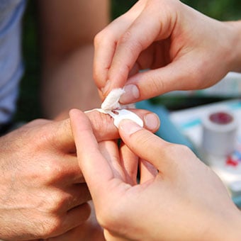 A man gets his finger cleaned and bandaged to prevent infection.