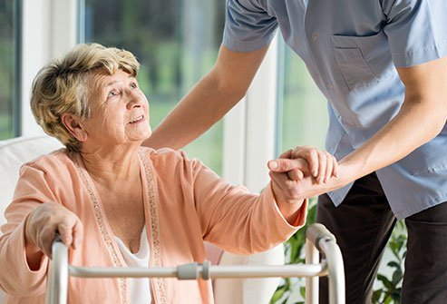 Woman receiving assistance standing up.