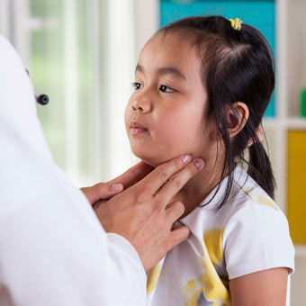 A doctor examines the lymph nodes of a little girl.
