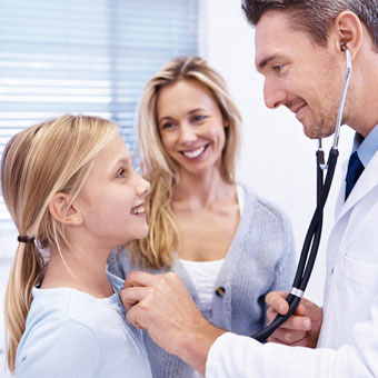 A doctor performs a follow-up exam on a girl.
