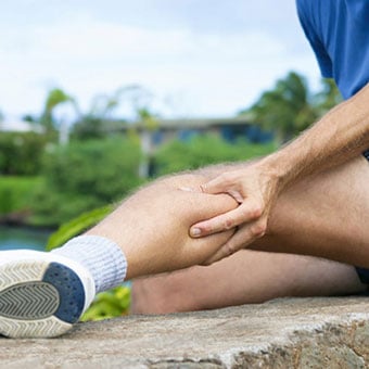 A runner experiences a muscle cramp in his calf.