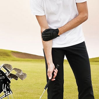 A man experiences a spasm in his arm while golfing.