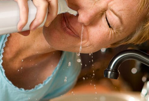 A woman snorting saline solution.