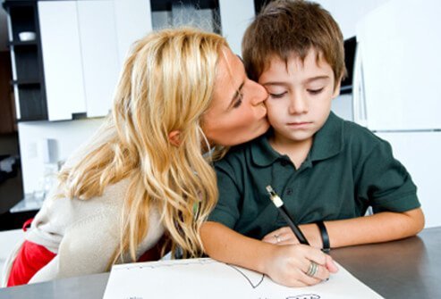 A mother kisses her son.