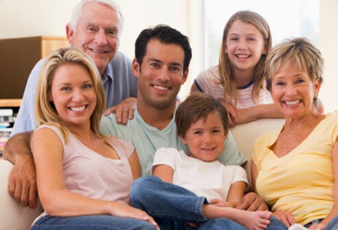 A happy extended family of grandparents, parents, and children pose for a picture.