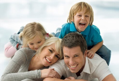 Happy parents play with their two children.