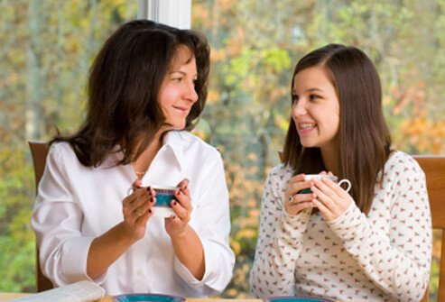 A mother and daughter have a discussion while drinking tea.