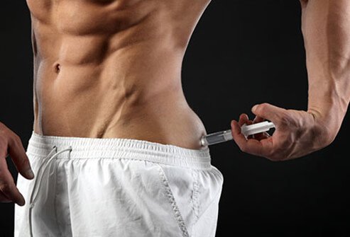 A man holds a syringe in from of his chest.